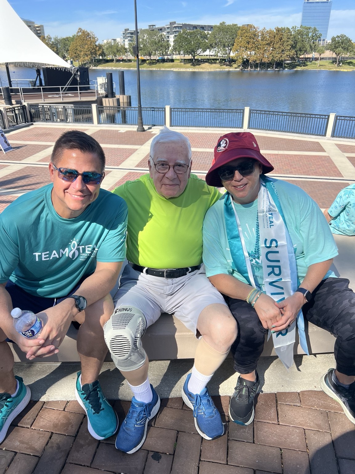 Juan and Margarita sitting together with a loved one by the water